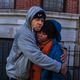 Emelia Ascheampong (right), a resident of the building where more than 10 people died in a fire Thursday, is embraced by a friend Dec. 29, 2017, in the Bronx borough of New York City. (Andres Kudacki/AP Images)